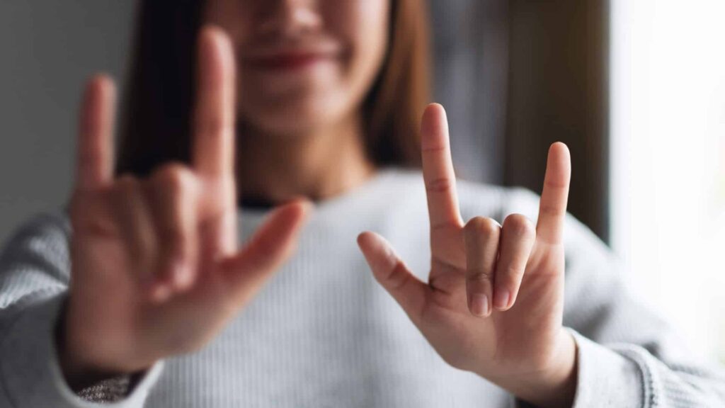 Girl holding up two hands sign language